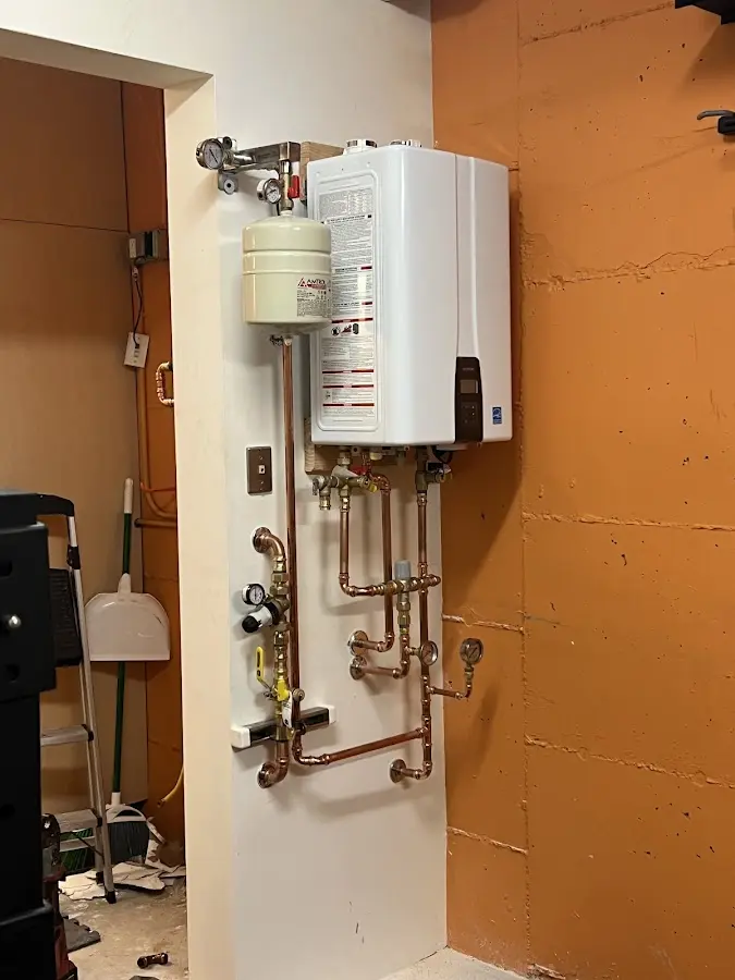 Plumbing technician inspecting water heater connections in Imperial